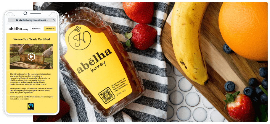 A smartphone next to a bottle of honey and an assortment of fruit.